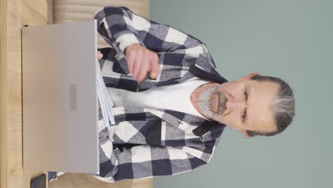 Vertical-video-of-Old-man-making-video-call-on-laptop.